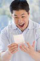 Man with winning lottery ticket excited and smiling