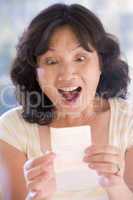 Woman with winning lottery ticket excited and smiling