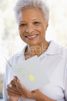 Woman reading card and smiling