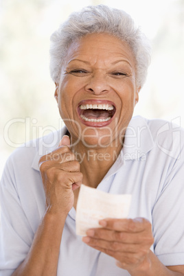 Woman with winning lottery ticket excited and smiling