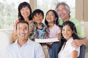 Family in living room with cake smiling