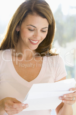 Woman reading letter smiling