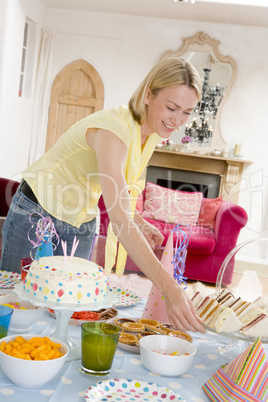Woman at party setting out food and smiling