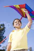 Young boy with kite outdoors smiling