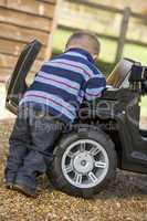 Young boy playing outdoors with toy truck