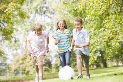 Three young friends playing soccer