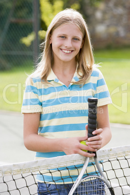 Young couple with rackets on tennis court smiling