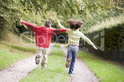Two young friends running on a path outdoors