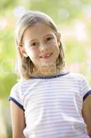 Young girl standing outdoors smiling