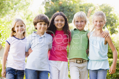 Five young friends standing outdoors smiling