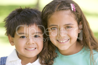 Brother and sister outdoors smiling