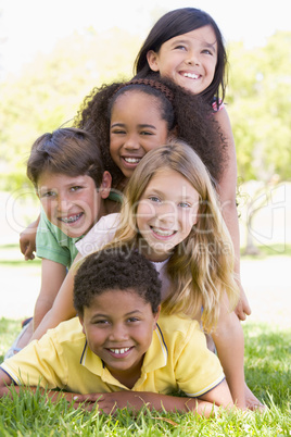 five children lying above each other in the meadow