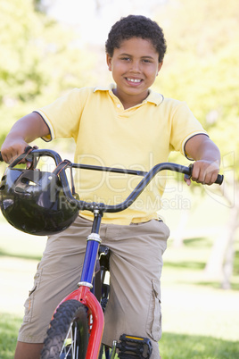 Young boy on bicycle outdoors smiling