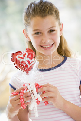 Young girl on Valentine's Day holding love themed balloon smilin