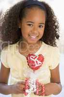 Young girl on Valentine's Day holding love themed balloon smilin