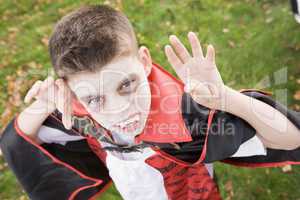 Young boy outdoors wearing vampire costume on Halloween