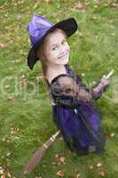 Young girl outdoors in witch costume on Halloween