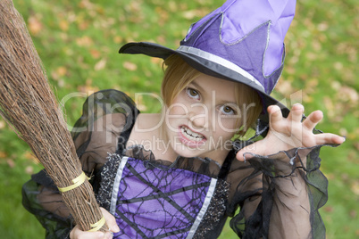 Young girl outdoors in witch costume on Halloween