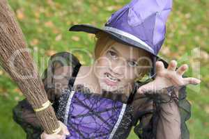 Young girl outdoors in witch costume on Halloween