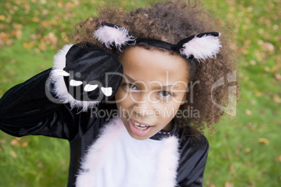 Young girl outdoors in cat costume on Halloween