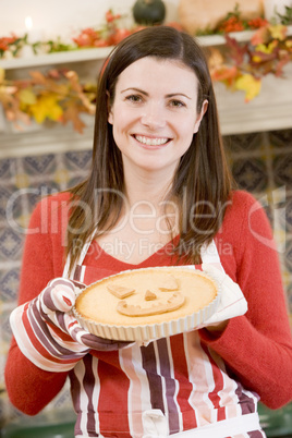 Woman in kitchen making Halloween treats and smiling