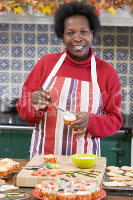 Woman in kitchen making Halloween treats and smiling