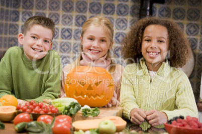 Three young friends on Halloween with jack o lantern and food sm