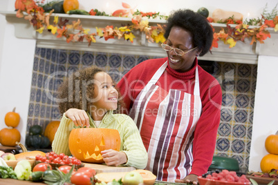 Grandmother and granddaughter making jack o lantern on Halloween