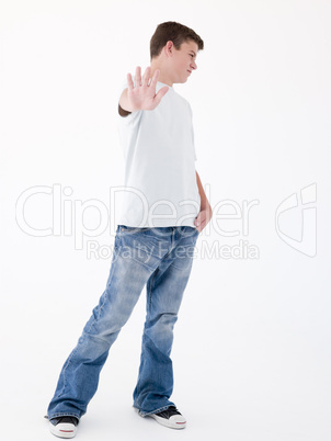 Teenage boy standing with hand up