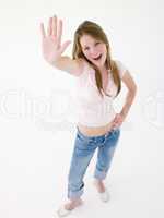 Teenage girl with hand up smiling