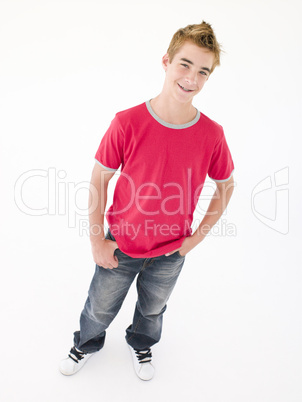 Teenage boy with hands in pockets smiling