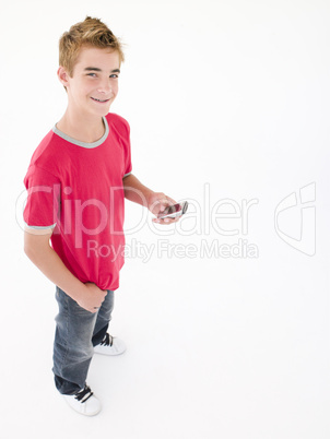 young boy holding cellular phone and smiling young boy holding cellular phone and smiling