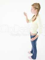Teenage girl looking at cellular phone and puckering up