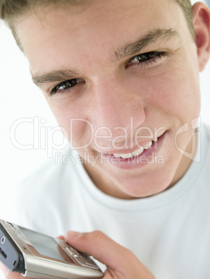 Teenage boy using cellular phone and smiling