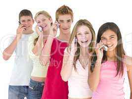 Row of five friends on cellular phones smiling