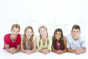 Five friends lying down in a row smiling