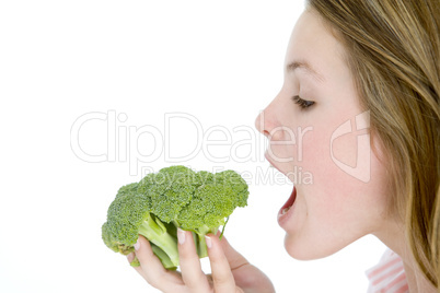 Teenage girl eating broccoli