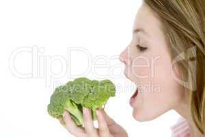 Teenage girl eating broccoli