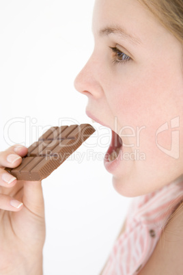 Teenage girl eating chocolate bar