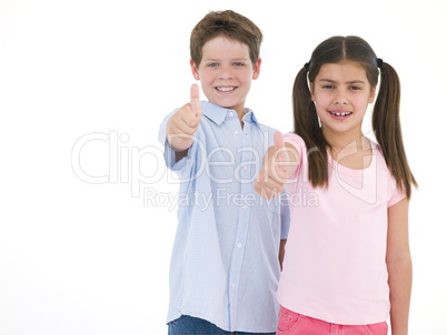 Brother and sister giving thumbs up smiling