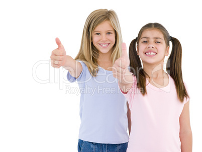 Two girl friends giving thumbs up smiling