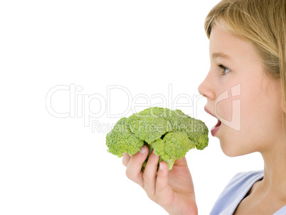 Young girl eating broccoli