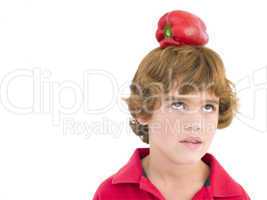 Young boy with red pepper on his head frowning
