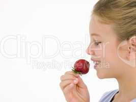 Young girl eating strawberry smiling