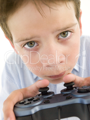 Young boy using videogame controller and concentrating