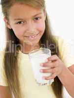 Young girl with glass of milk smiling