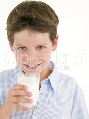 Young boy with glass of milk smiling