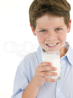 Young boy with glass of milk smiling