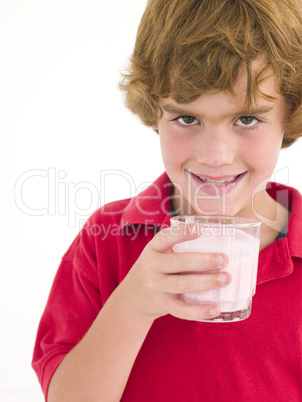 Young boy with glass of milk smiling