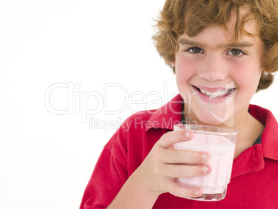 Young boy with glass of milk smiling